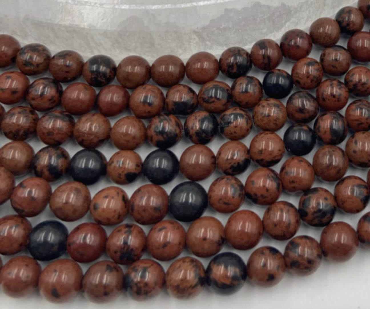 Obsidienne Acajou, perles rondes de 6 ou 8 mm. Vendu en fil de perle 38/39 cm, en bracelet de 17 à 21cm, en collier de 45 ou sautoir de 60cm. Qualité AA à AAA, superbes perles !