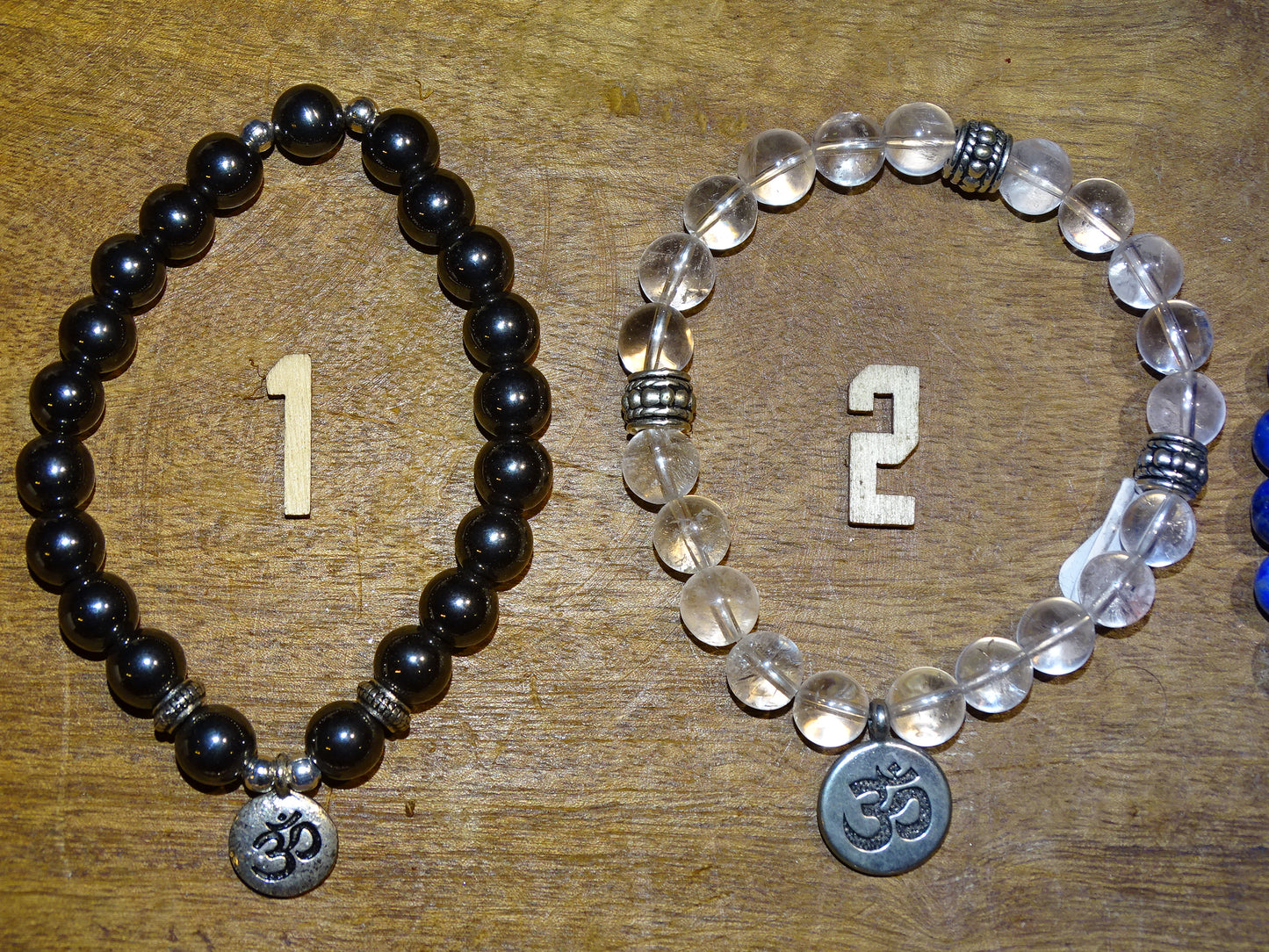 Collection de bracelets avec 3 charms au choix : Lotus Om ou Bouddha... En perle de 8mm + Médaille gravée de couleur argenté. Longueur au choix de 17 à 21 cm. Fait main par Zen Curiosity !