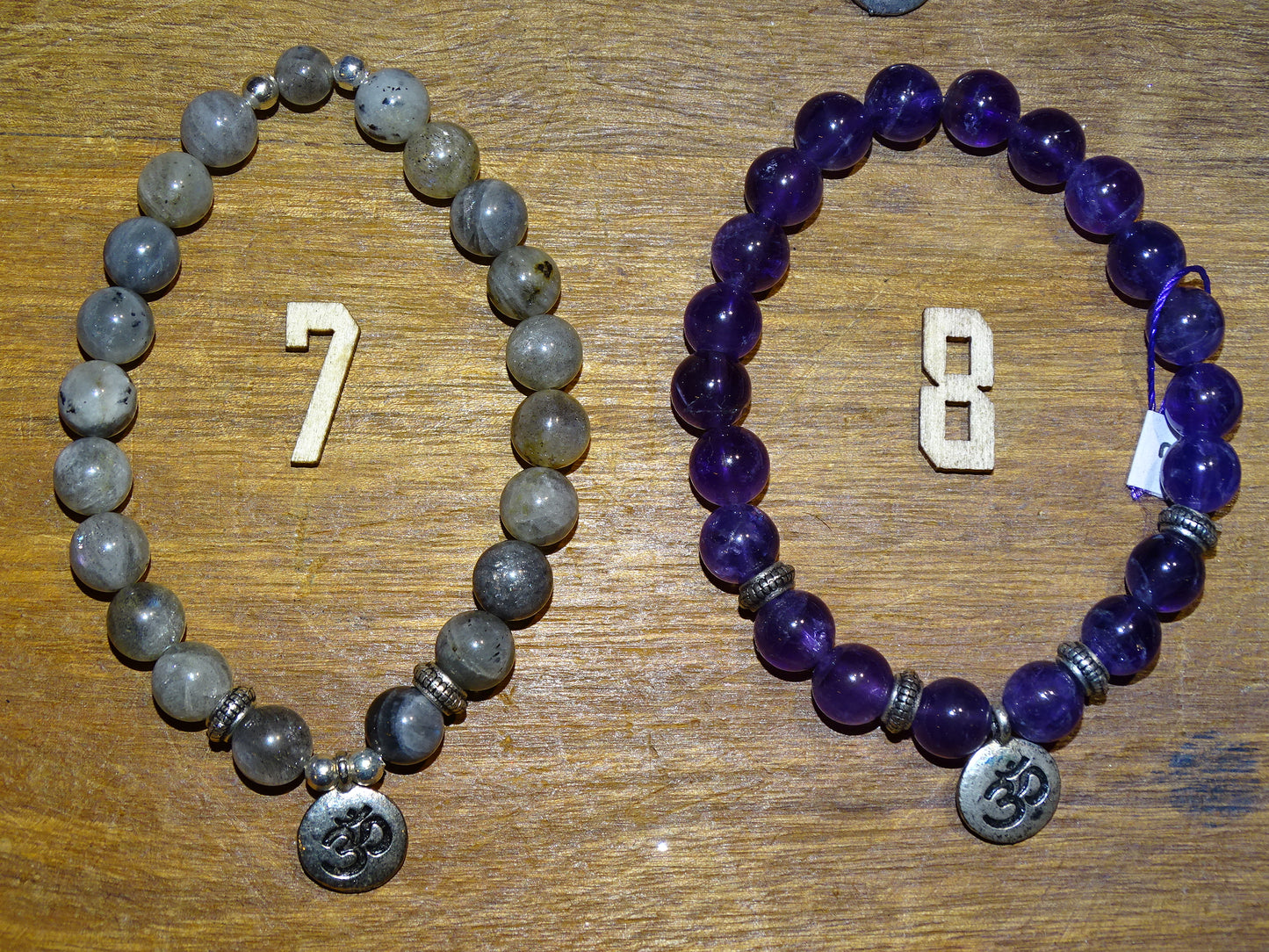 Collection de bracelets avec 3 charms au choix : Lotus Om ou Bouddha... En perle de 8mm + Médaille gravée de couleur argenté. Longueur au choix de 17 à 21 cm. Fait main par Zen Curiosity !