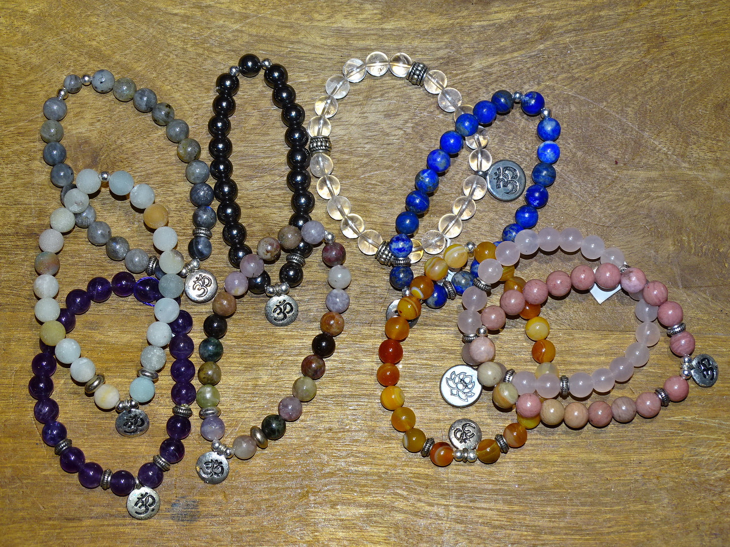 Collection de bracelets avec 3 charms au choix : Lotus Om ou Bouddha... En perle de 8mm + Médaille gravée de couleur argenté. Longueur au choix de 17 à 21 cm. Fait main par Zen Curiosity !