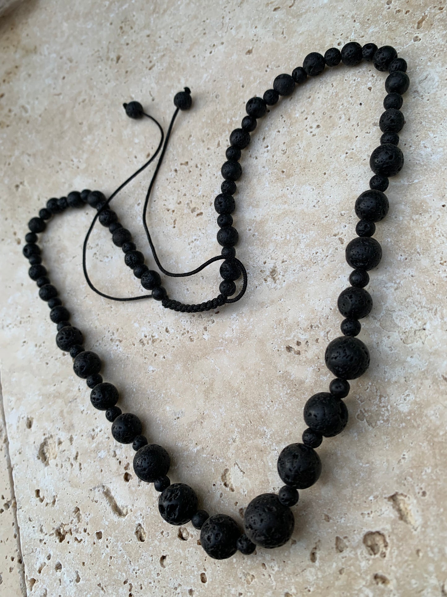 Pierre de lave, 'collier/ chute de perle', de forme ronde de 4 à 10 mm -50 cm. Fermeture coullissante. très belle pièce !