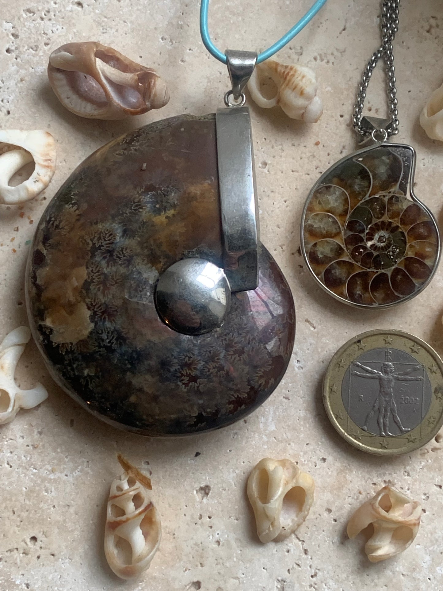 Fossil ammonite pendants, available in two sizes: 60x50x20 and 35x25x10 mm. Each piece is authentic and unique, revealing the natural spirals and fascinating patterns of this fossil. Comes with a drawstring, ready to wear or give as a gift!