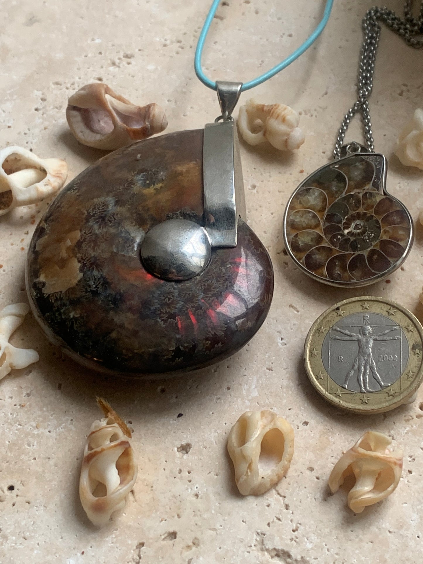 Fossil ammonite pendants, available in two sizes: 60x50x20 and 35x25x10 mm. Each piece is authentic and unique, revealing the natural spirals and fascinating patterns of this fossil. Comes with a drawstring, ready to wear or give as a gift!