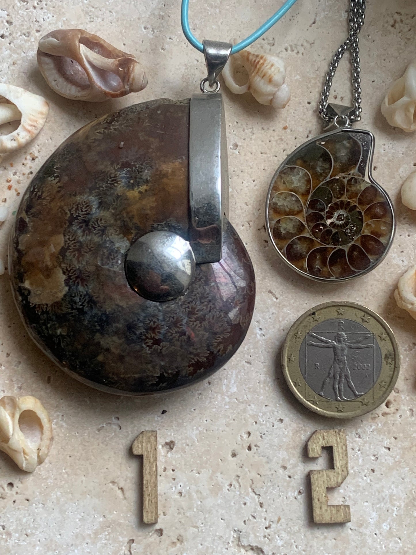 Fossil ammonite pendants, available in two sizes: 60x50x20 and 35x25x10 mm. Each piece is authentic and unique, revealing the natural spirals and fascinating patterns of this fossil. Comes with a drawstring, ready to wear or give as a gift!