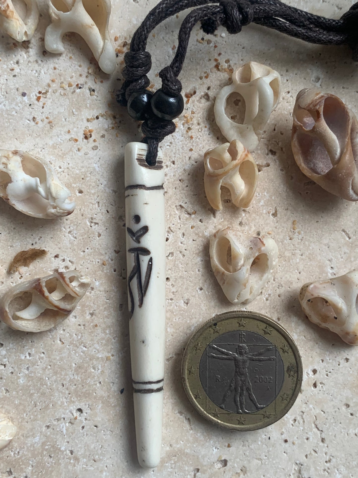 Elegant handcrafted pendant from Nepal, carved from bone with the sacred Om symbol, 60 millimeters high x 10 millimeters in diameter. Sold with a free adjustable black cord, perfect!