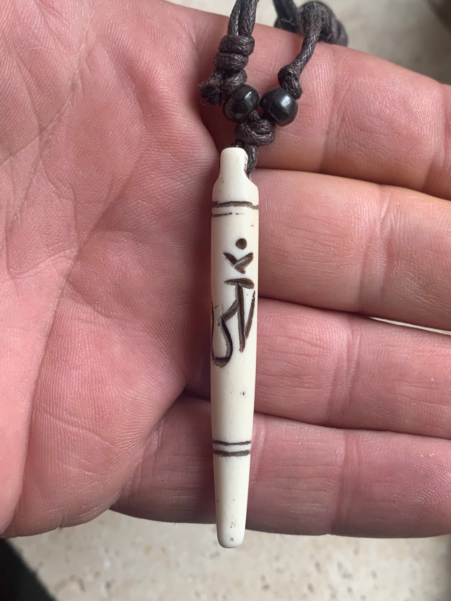 Elegant handcrafted pendant from Nepal, carved from bone with the sacred Om symbol, 60 millimeters high x 10 millimeters in diameter. Sold with a free adjustable black cord, perfect!