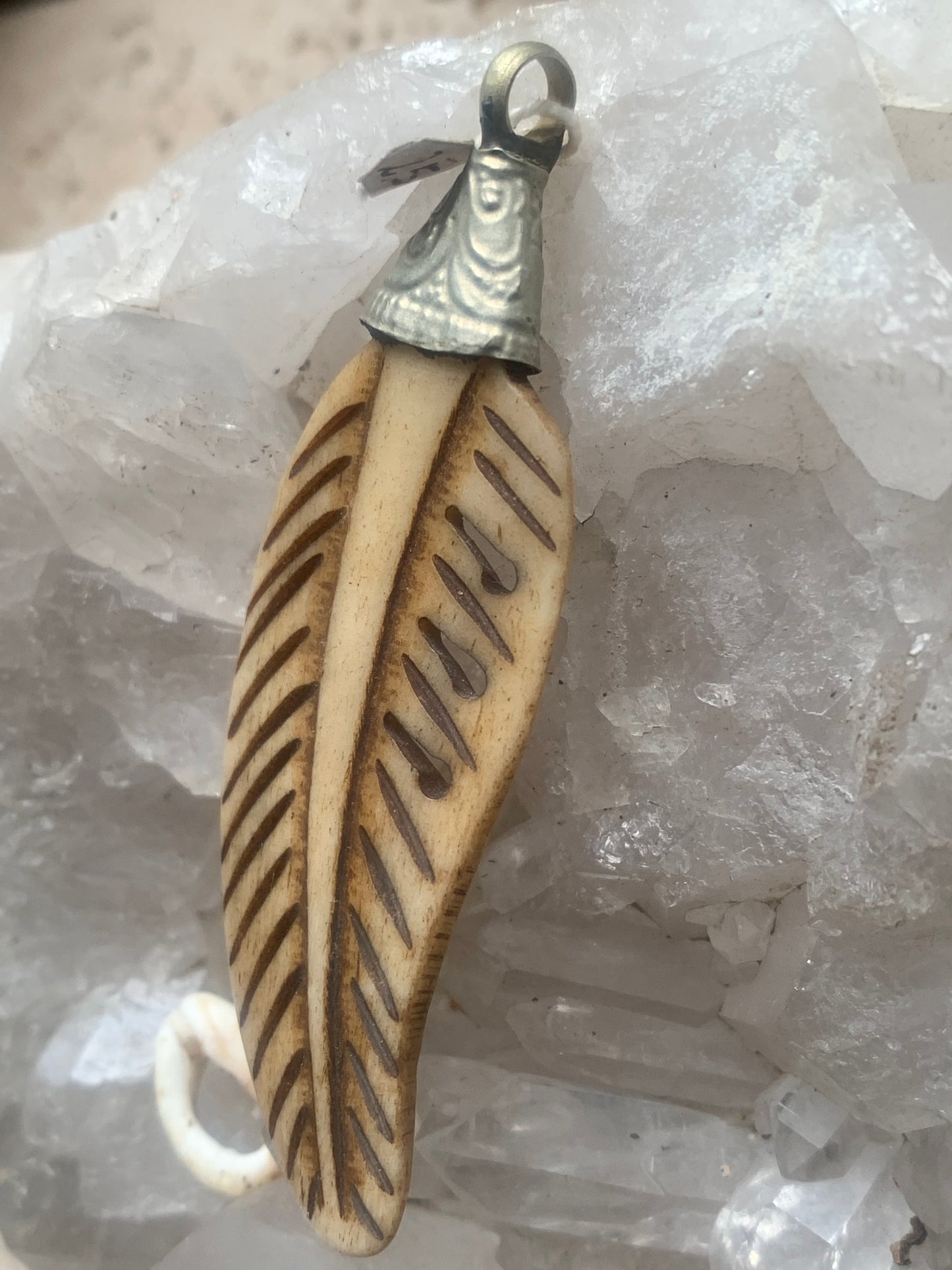 Handcrafted feather-shaped pendant from Nepal, carved from bone, measuring 70 millimeters high x 22 wide x 5 thick. Sold with a free adjustable black cord, perfect!