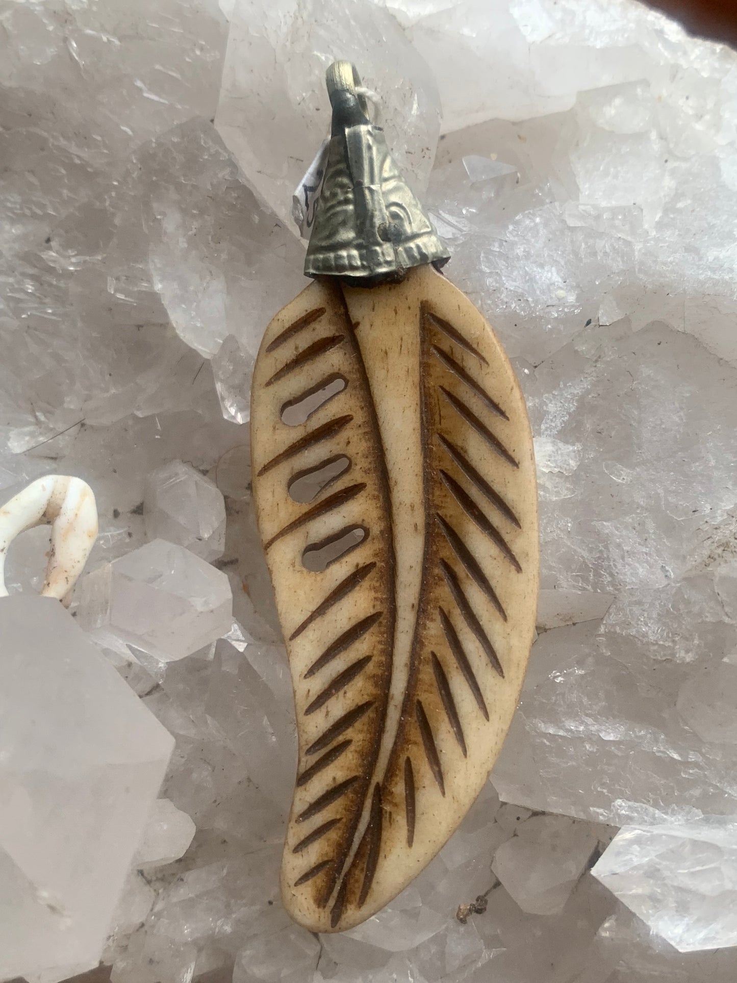 Handcrafted feather-shaped pendant from Nepal, carved from bone, measuring 70 millimeters high x 22 wide x 5 thick. Sold with a free adjustable black cord, perfect!