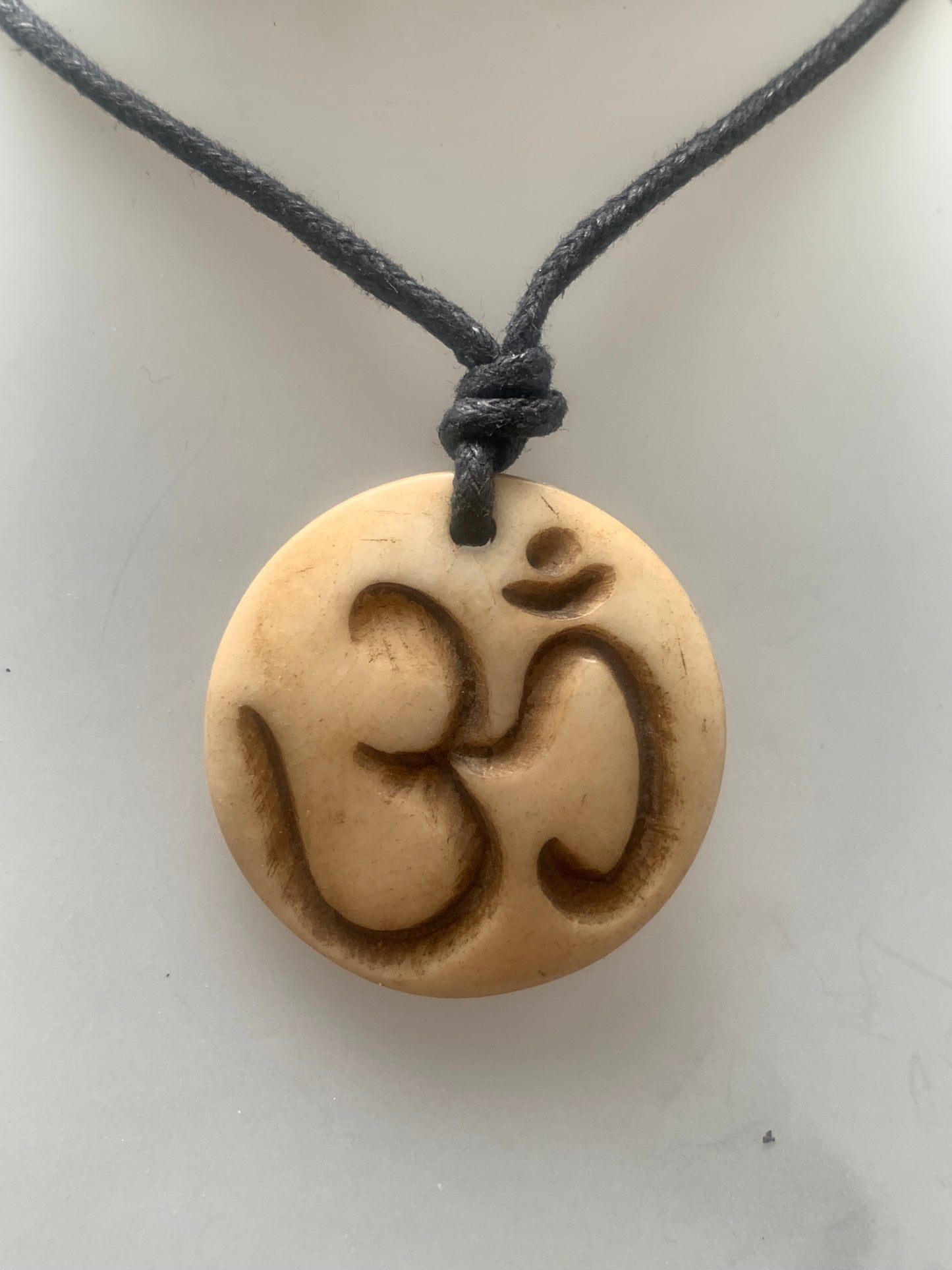 Handcrafted pendant from Nepal with Om symbol, carved from bone, 30 millimeters in diameter x 4 mm thick. Sold with a free adjustable black cord, perfect!