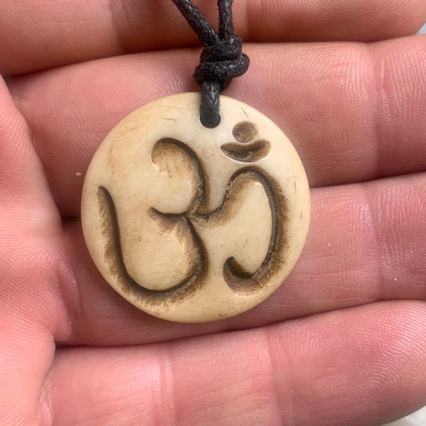 Handcrafted pendant from Nepal with Om symbol, carved from bone, 30 millimeters in diameter x 4 mm thick. Sold with a free adjustable black cord, perfect!