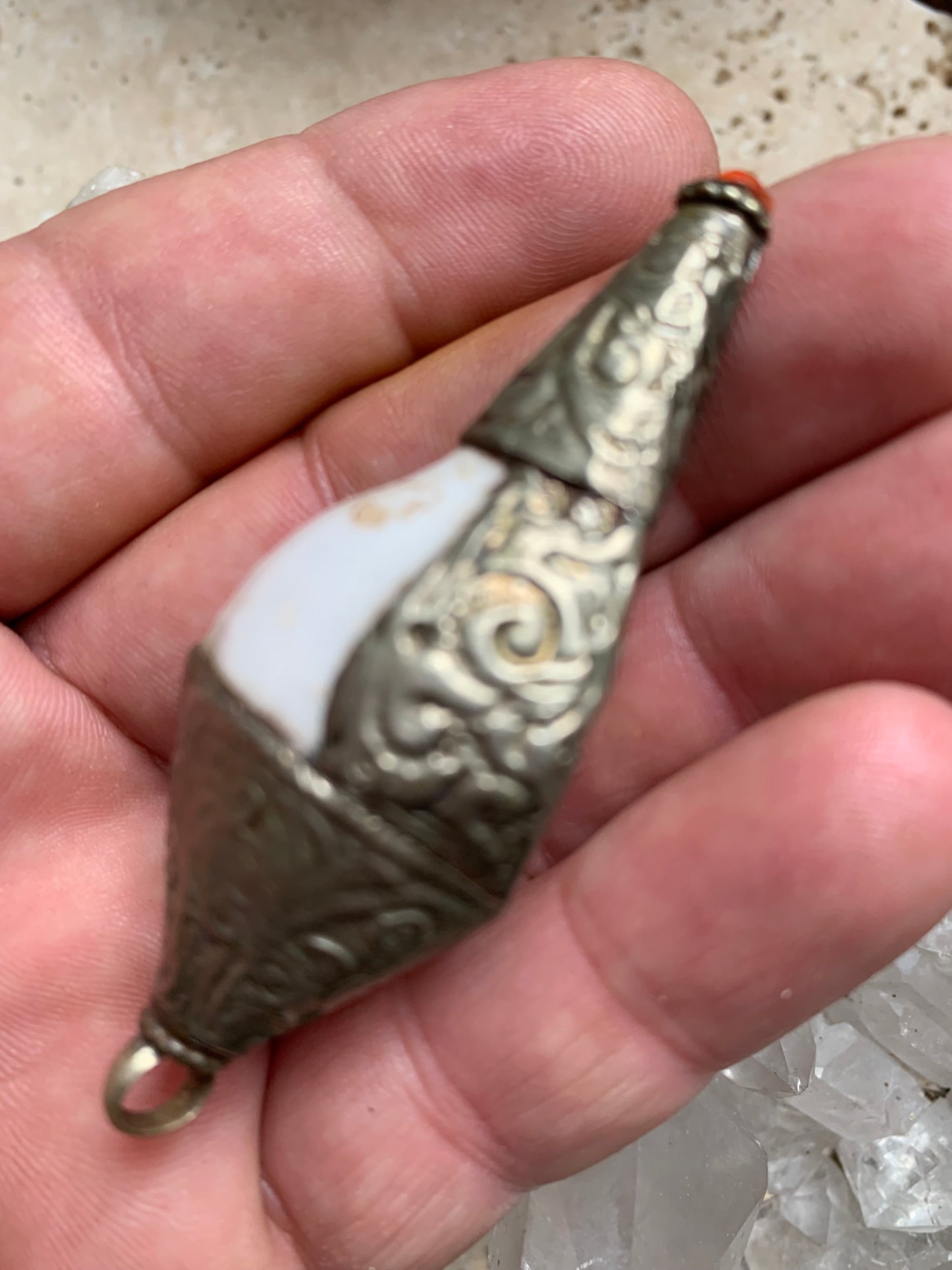 Handcrafted Nepalese shell pendant set in metal with beautiful engravings and a coral bead! 65 millimeters high x 28 mm in diameter. Sold with a free adjustable black cord, perfect!