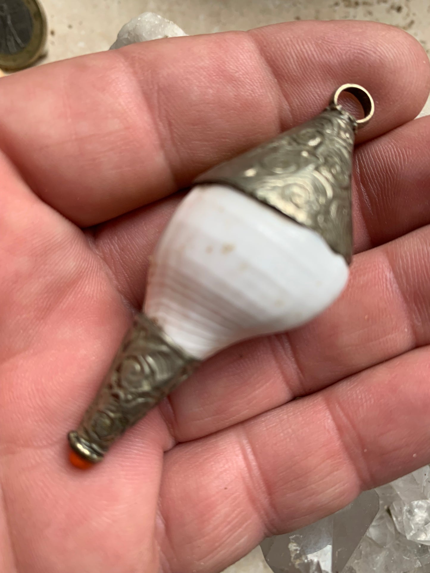 Handcrafted Nepalese shell pendant set in metal with beautiful engravings and a coral bead! 65 millimeters high x 28 mm in diameter. Sold with a free adjustable black cord, perfect!