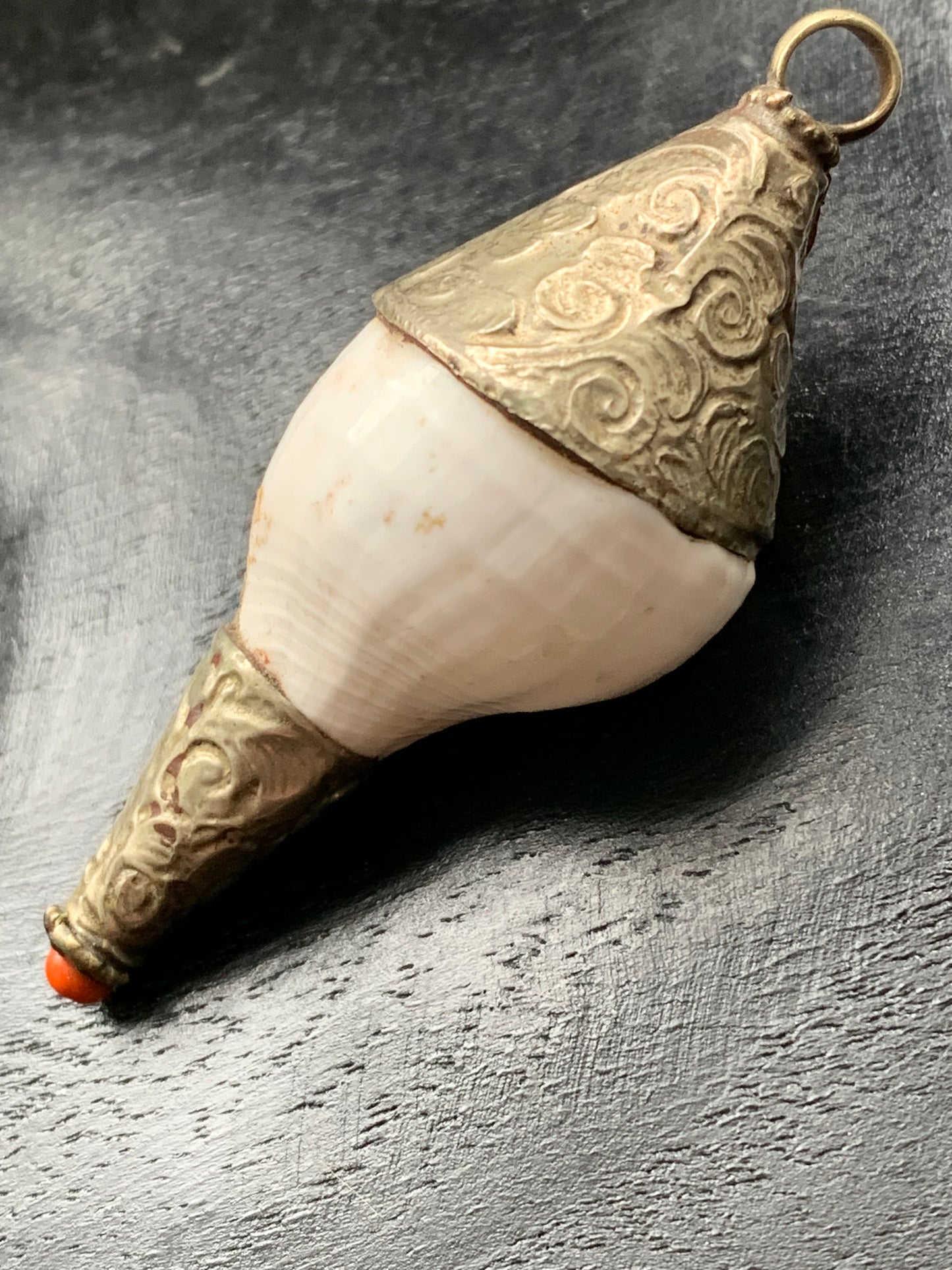 Handcrafted Nepalese shell pendant set in metal with beautiful engravings and a coral bead! 65 millimeters high x 28 mm in diameter. Sold with a free adjustable black cord, perfect!