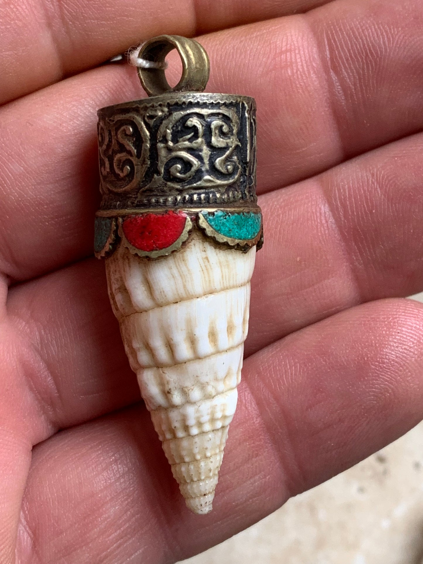 Handcrafted Nepalese shell pendant set in metal with beautiful engravings and turquoise with coral! 53 millimeters high x 18 mm in diameter. Sold with a free adjustable black cord, perfect!