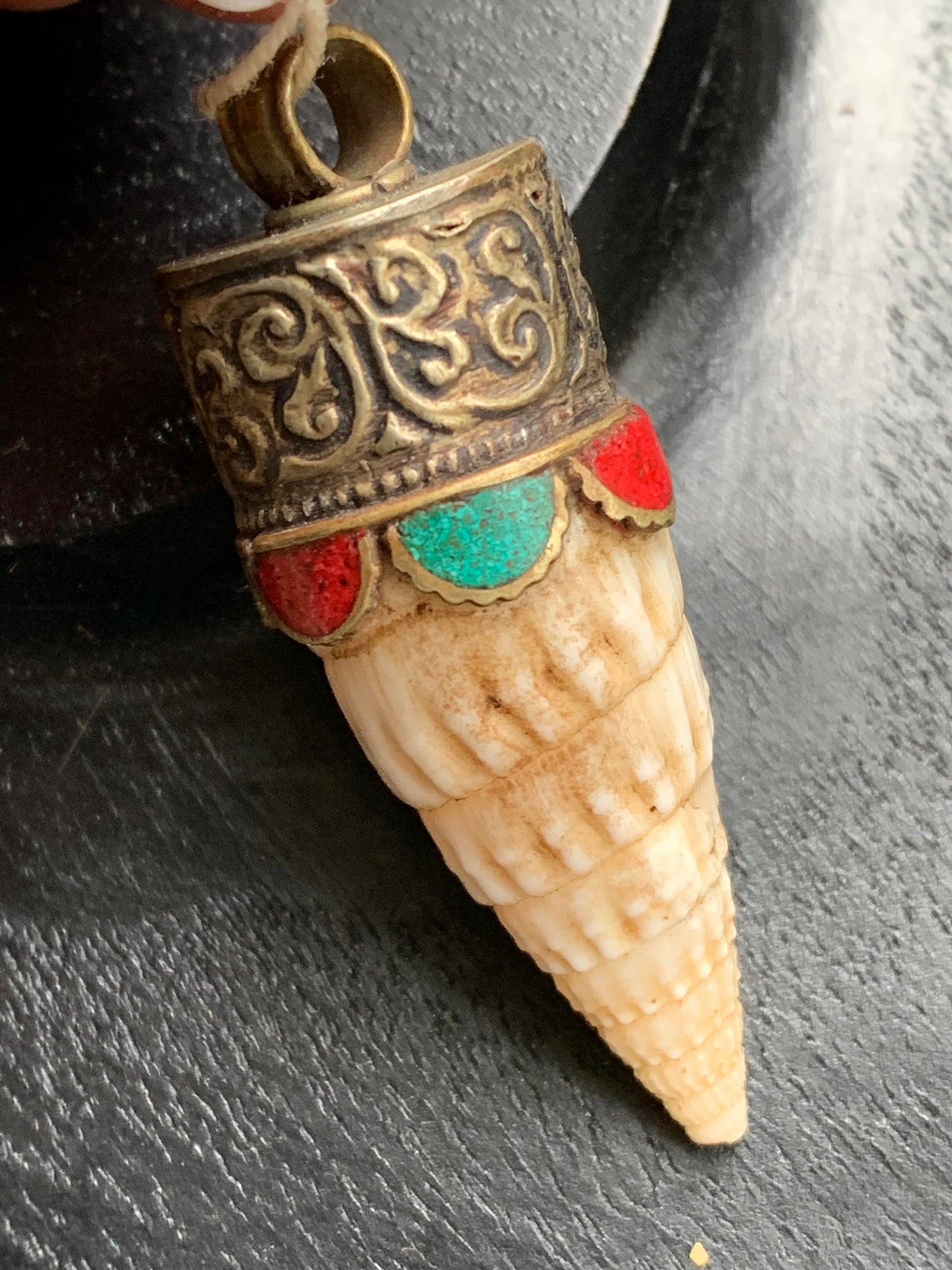 Handcrafted Nepalese shell pendant set in metal with beautiful engravings and turquoise with coral! 53 millimeters high x 18 mm in diameter. Sold with a free adjustable black cord, perfect!