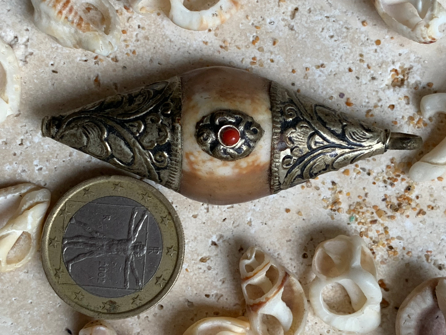Handcrafted Nepalese shell pendant set in metal with pretty engravings and a coral bead! 60 millimeters high x 23 mm wide x 16 mm thick. Sold with a free adjustable black cord, perfect!