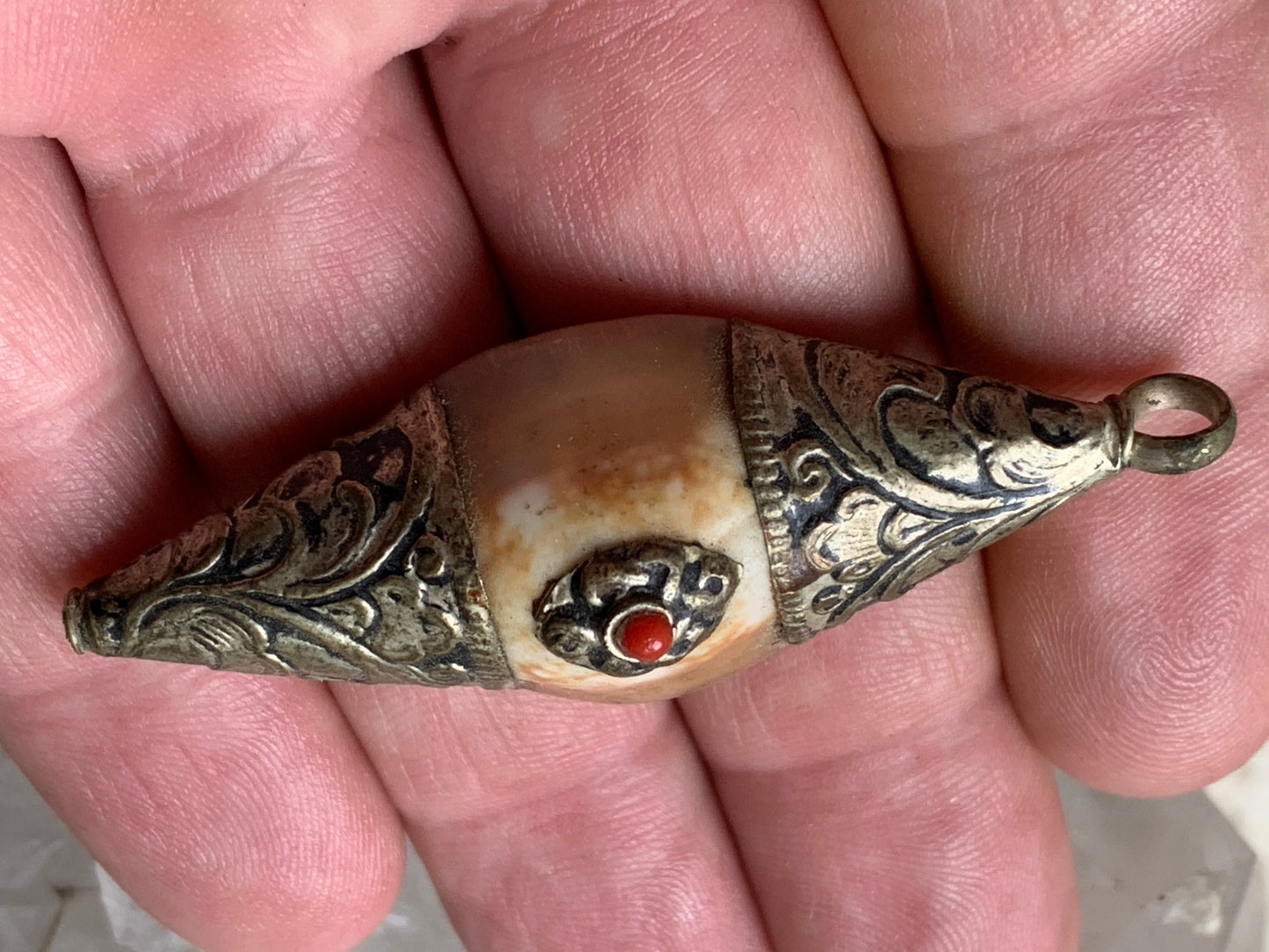 Handcrafted Nepalese shell pendant set in metal with pretty engravings and a coral bead! 60 millimeters high x 23 mm wide x 16 mm thick. Sold with a free adjustable black cord, perfect!