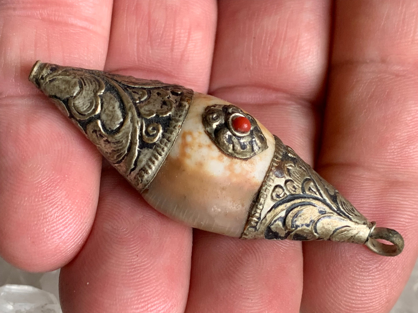 Handcrafted Nepalese shell pendant set in metal with pretty engravings and a coral bead! 60 millimeters high x 23 mm wide x 16 mm thick. Sold with a free adjustable black cord, perfect!