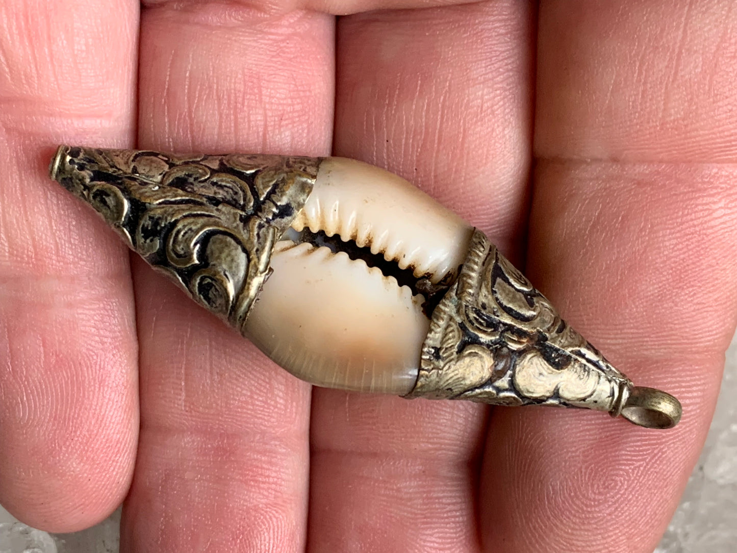 Handcrafted Nepalese shell pendant set in metal with pretty engravings and a coral bead! 60 millimeters high x 23 mm wide x 16 mm thick. Sold with a free adjustable black cord, perfect!