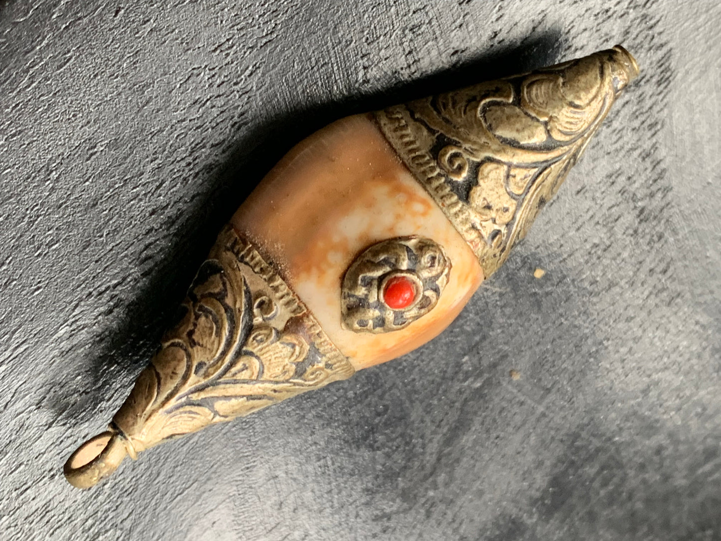 Handcrafted Nepalese shell pendant set in metal with pretty engravings and a coral bead! 60 millimeters high x 23 mm wide x 16 mm thick. Sold with a free adjustable black cord, perfect!