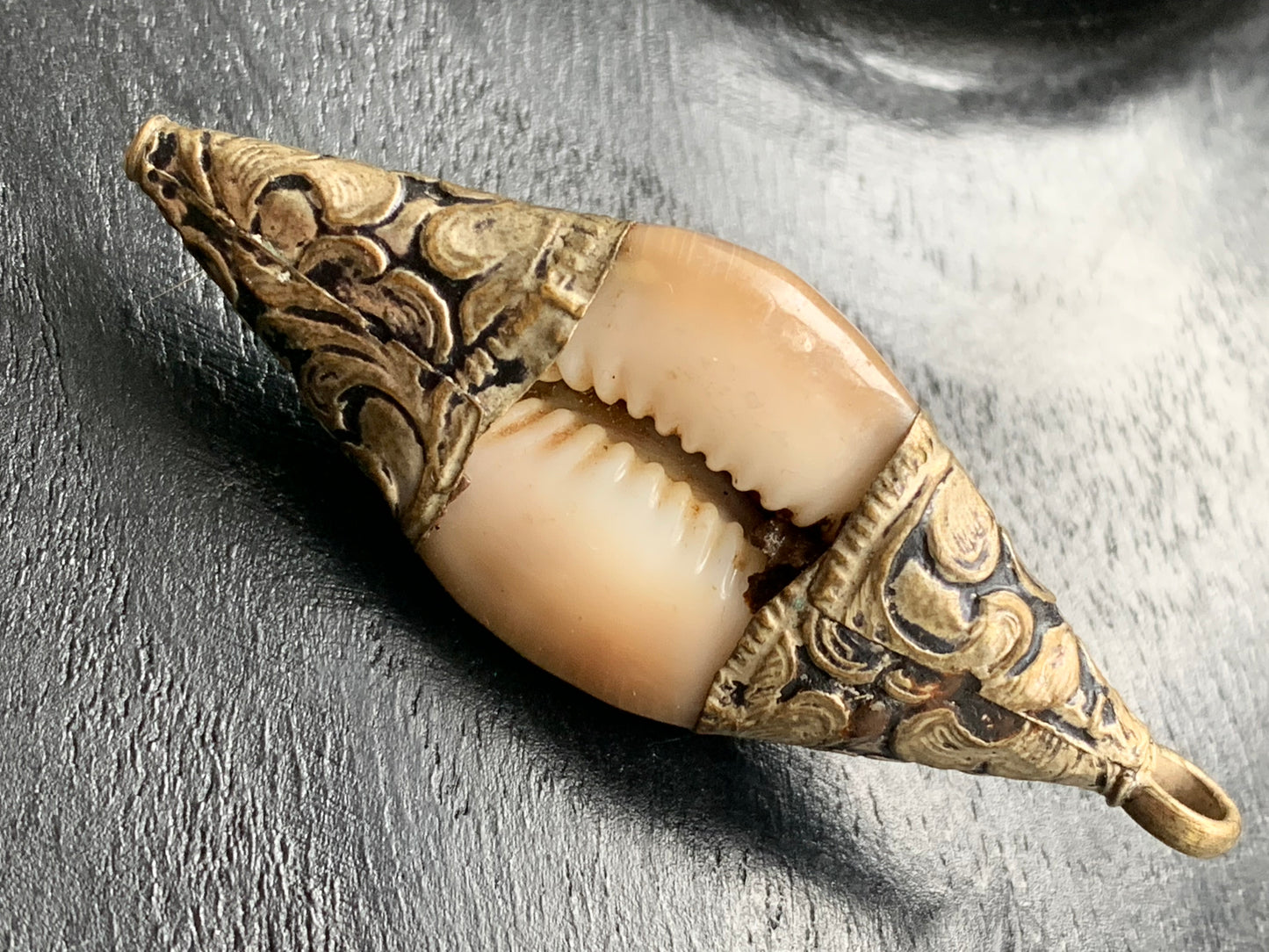 Handcrafted Nepalese shell pendant set in metal with pretty engravings and a coral bead! 60 millimeters high x 23 mm wide x 16 mm thick. Sold with a free adjustable black cord, perfect!