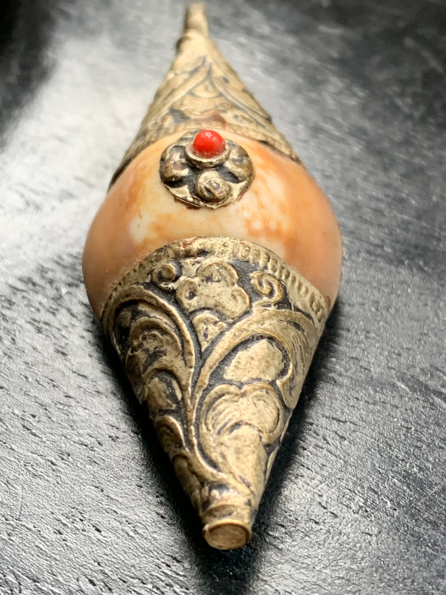 Handcrafted Nepalese shell pendant set in metal with pretty engravings and a coral bead! 60 millimeters high x 23 mm wide x 16 mm thick. Sold with a free adjustable black cord, perfect!