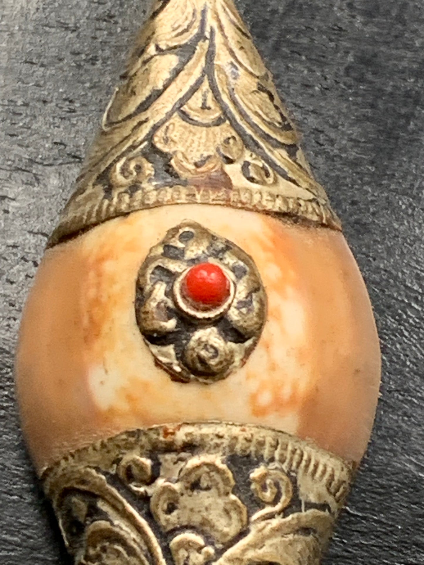 Handcrafted Nepalese shell pendant set in metal with pretty engravings and a coral bead! 60 millimeters high x 23 mm wide x 16 mm thick. Sold with a free adjustable black cord, perfect!
