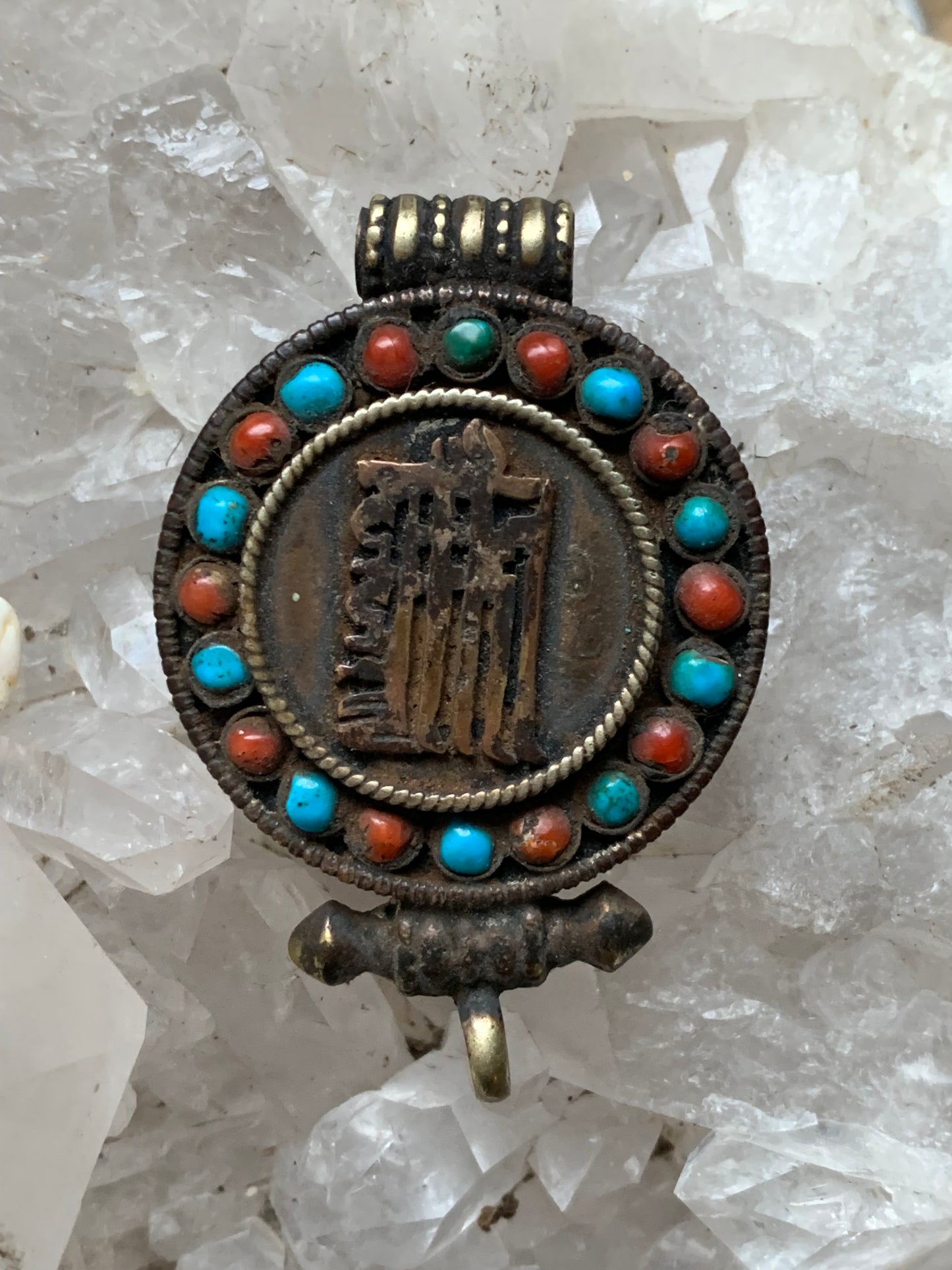 Pendentif/ Reliquaire artisanal du Népal avec pierres de turquoise et de corail sertis sur métal avec jolie gravure du Om ! De 52 millimètres de hauteur x 35 mm de largeur x 11 d'épaisseur. Vendu avec cordon noir réglable offert, parfait !