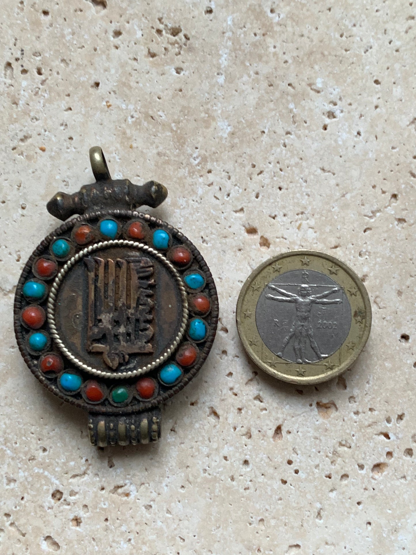 Pendentif/ Reliquaire artisanal du Népal avec pierres de turquoise et de corail sertis sur métal avec jolie gravure du Om ! De 52 millimètres de hauteur x 35 mm de largeur x 11 d'épaisseur. Vendu avec cordon noir réglable offert, parfait !