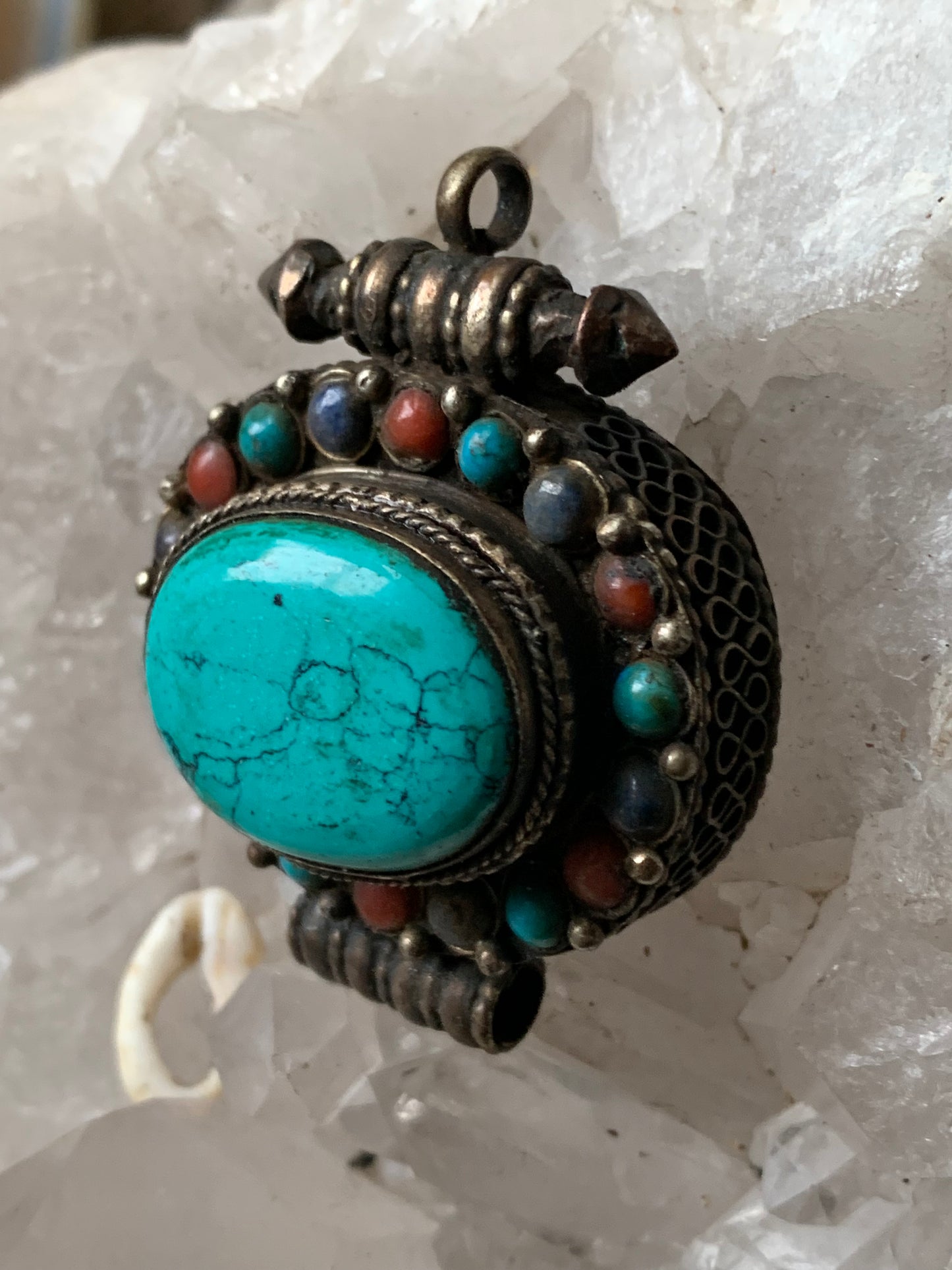 Pendentif/ Reliquaire artisanal du Népal avec pierres de turquoise et de corail sertis sur métal ! De 48 millimètres de hauteur x 37 mm de largeur x 18 d'épaisseur. Vendu avec cordon noir réglable offert, parfait !
