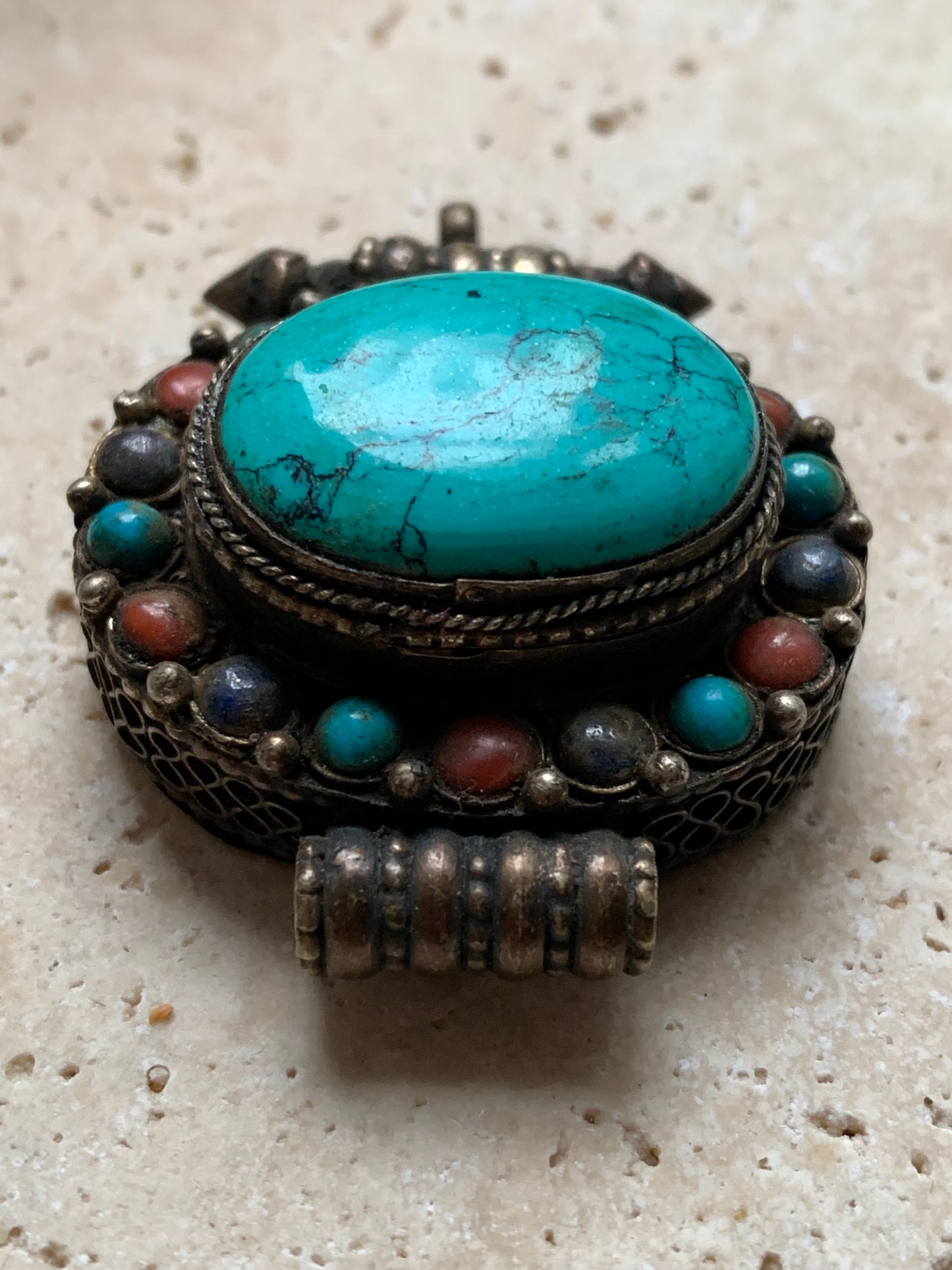 Pendentif/ Reliquaire artisanal du Népal avec pierres de turquoise et de corail sertis sur métal ! De 48 millimètres de hauteur x 37 mm de largeur x 18 d'épaisseur. Vendu avec cordon noir réglable offert, parfait !