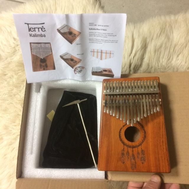 Kalimba 'Koa'/ Piano a doigt - 17 notes, fait en bois de koa (bois de résonance tropical) accordé en Do/ C majeur. Décoré d'un motif indien sculpté et est livrée avec un sac en tissu et un marteau d'accordage ! 23x19x7,5 cm !