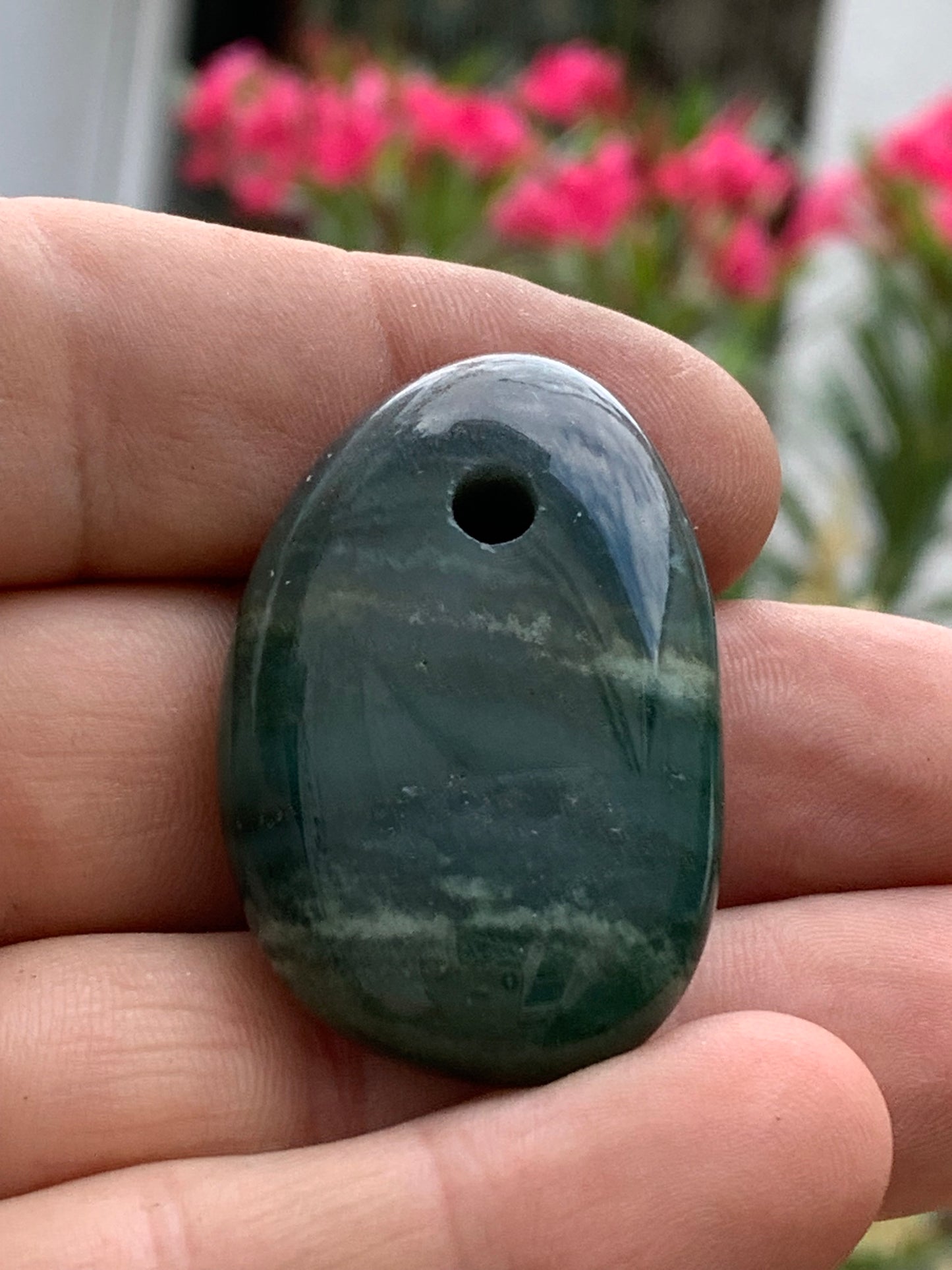 Jade, drilled pebble 43 mm high x 30 wide x 12 thick. Sold with adjustable black cord.