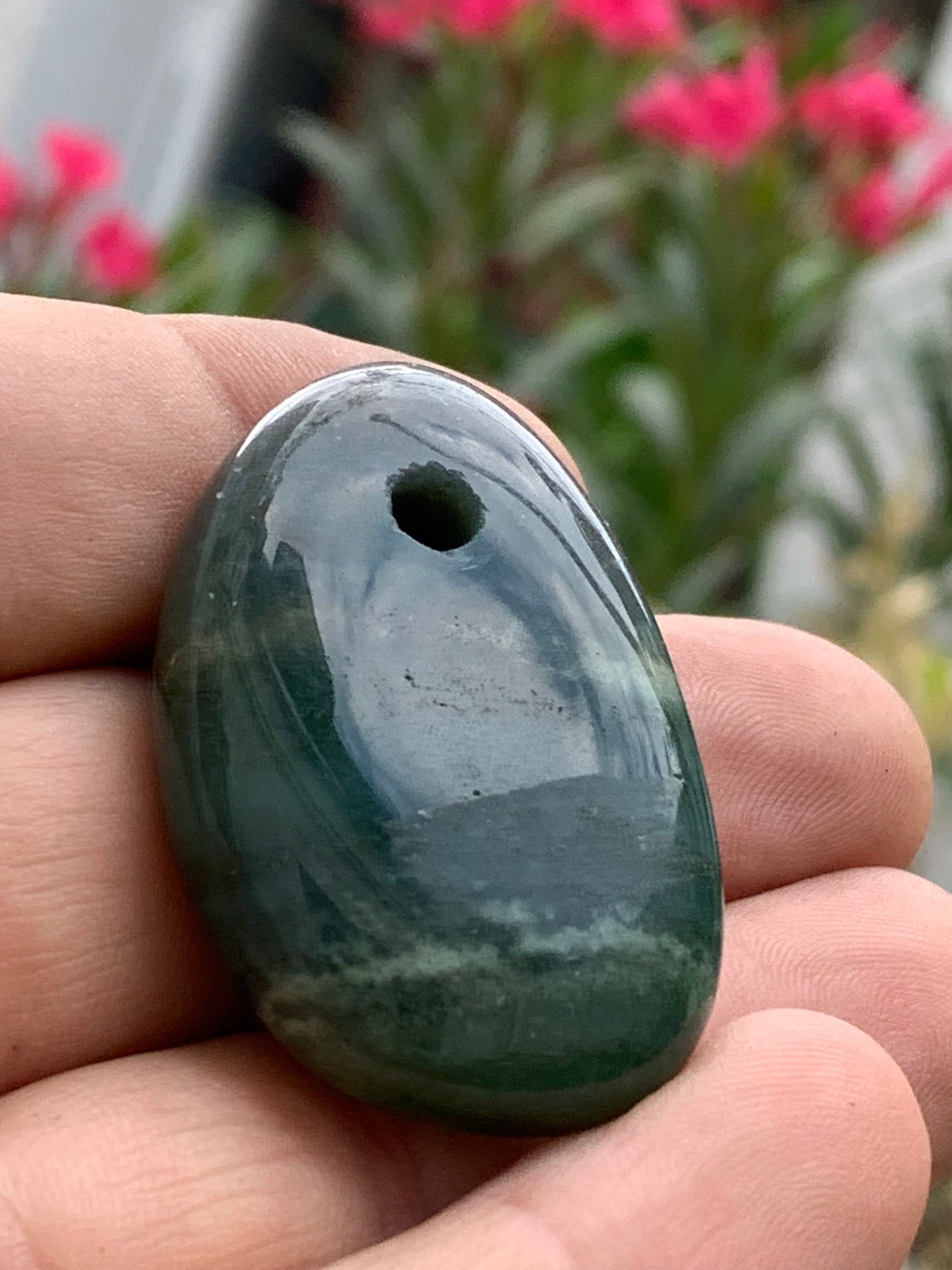 Jade, drilled pebble 43 mm high x 30 wide x 12 thick. Sold with adjustable black cord.