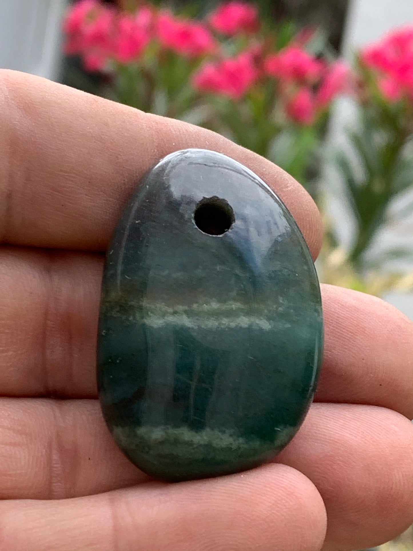 Jade, drilled pebble 43 mm high x 30 wide x 12 thick. Sold with adjustable black cord.
