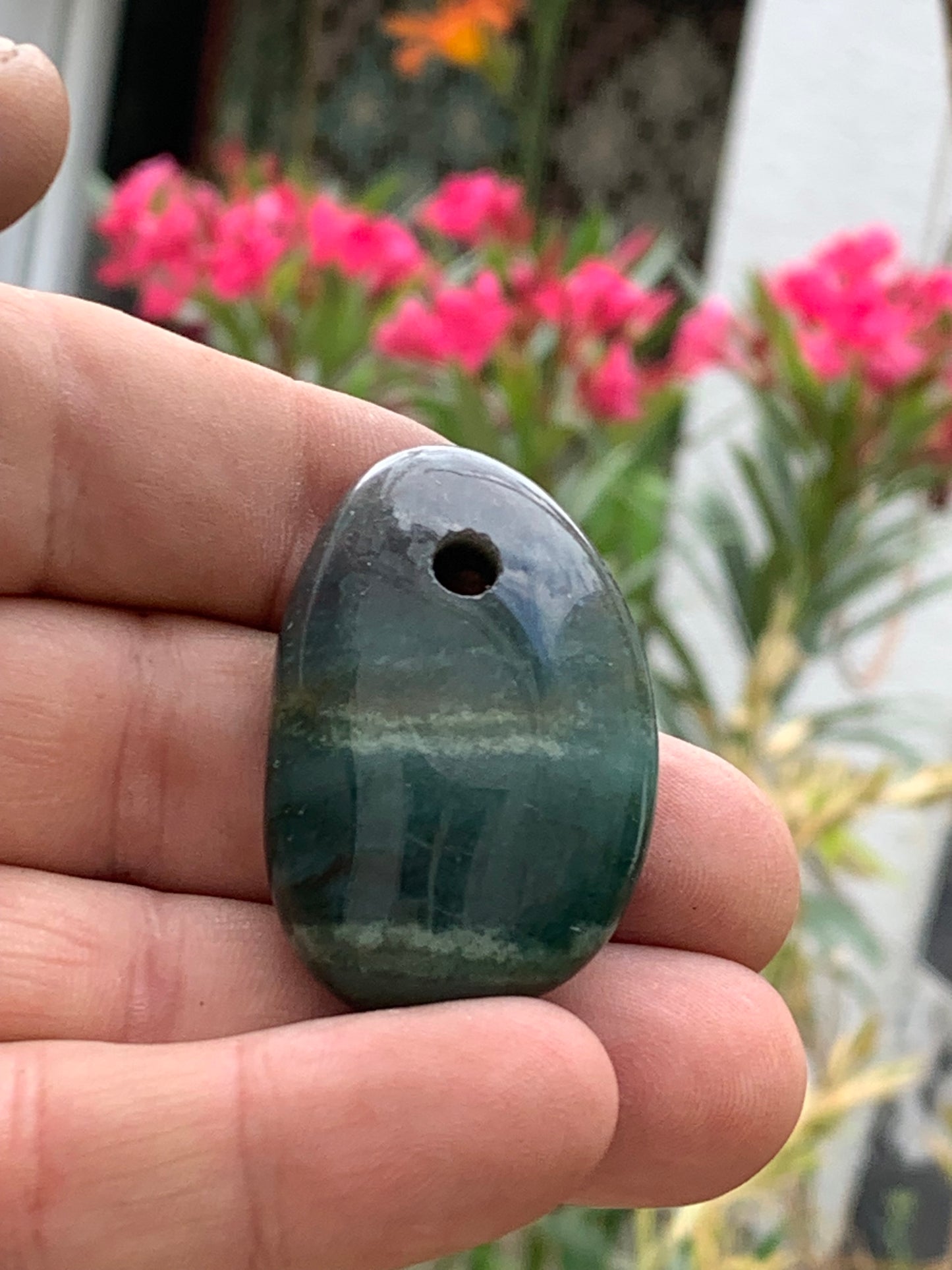 Jade, drilled pebble 43 mm high x 30 wide x 12 thick. Sold with adjustable black cord.