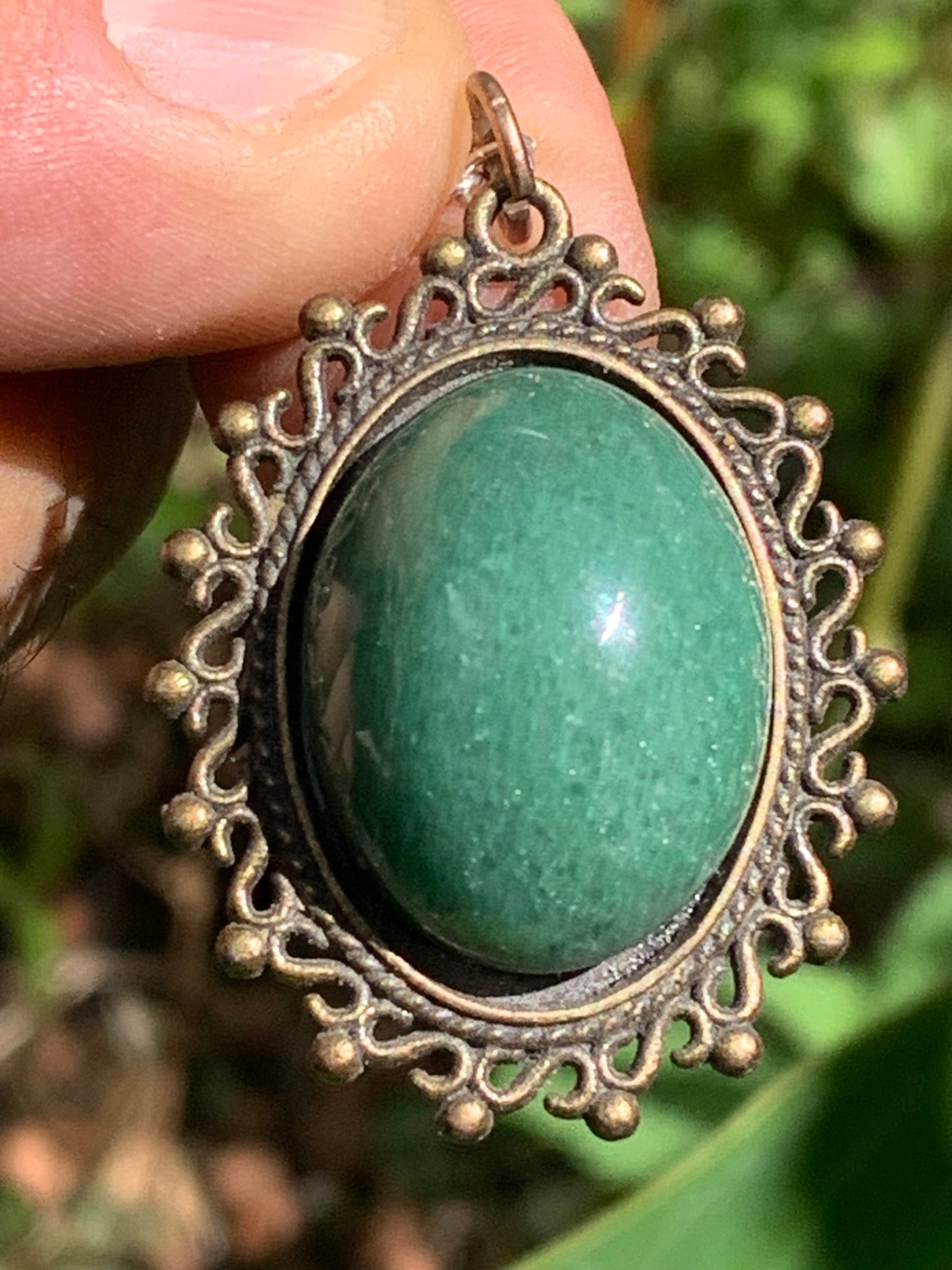 Médaillon couleur Bronze avec Aventurine/ quartz vert, de 36 mm de ht x30 x3. Vendu avec un cordon noir réglable !