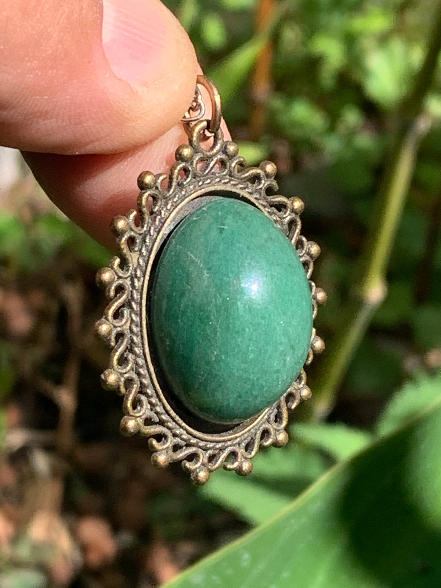 Médaillon couleur Bronze avec Aventurine/ quartz vert, de 36 mm de ht x30 x3. Vendu avec un cordon noir réglable !