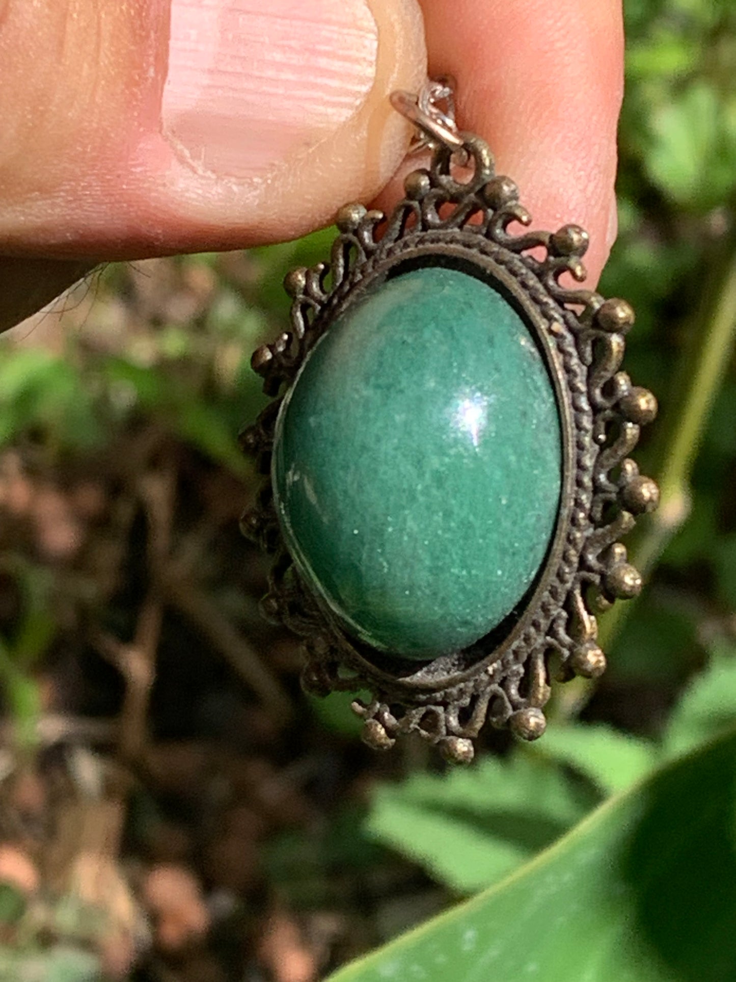 Médaillon couleur Bronze avec Aventurine/ quartz vert, de 36 mm de ht x30 x3. Vendu avec un cordon noir réglable !