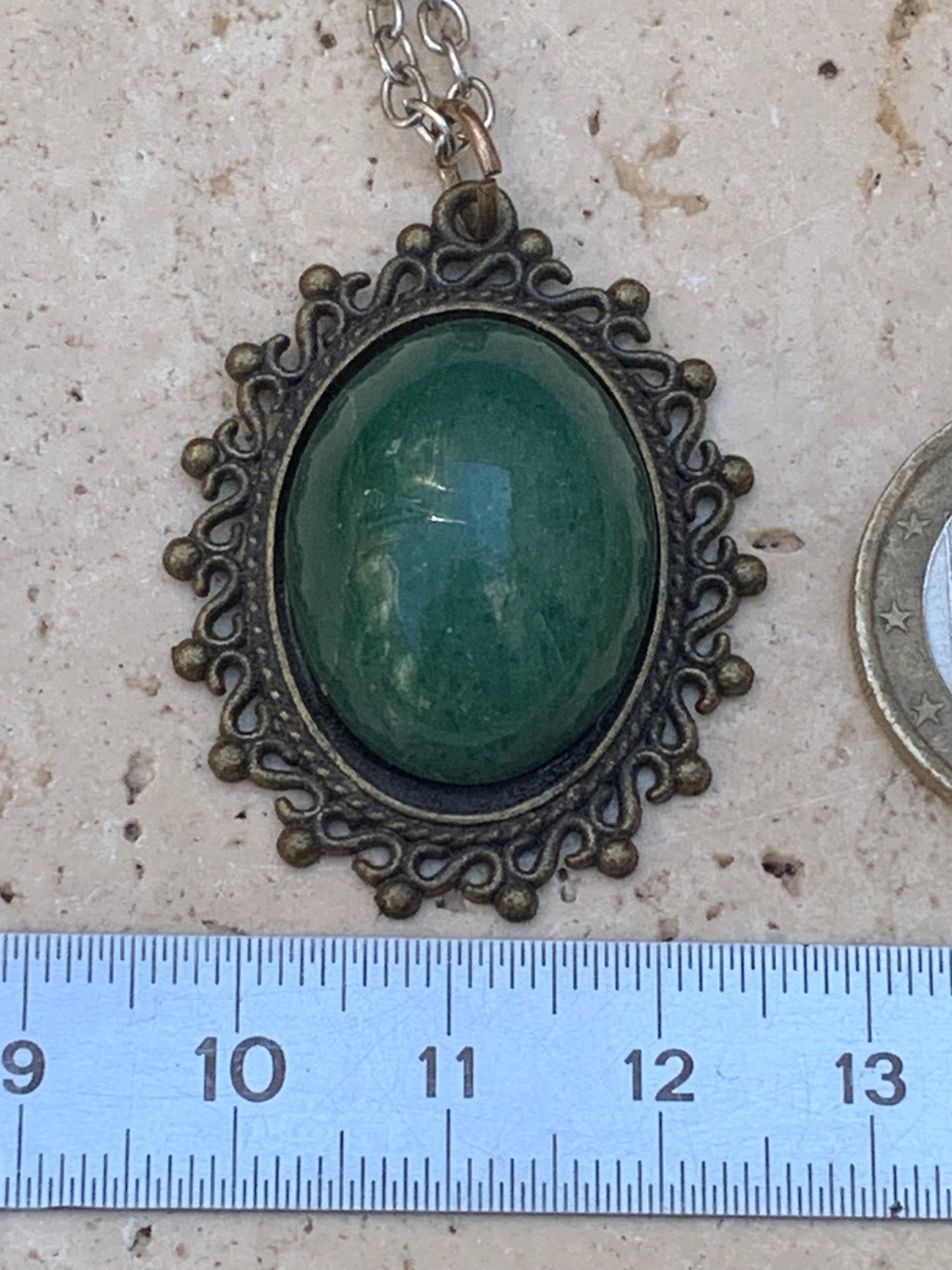 Médaillon couleur Bronze avec Aventurine/ quartz vert, de 36 mm de ht x30 x3. Vendu avec un cordon noir réglable !