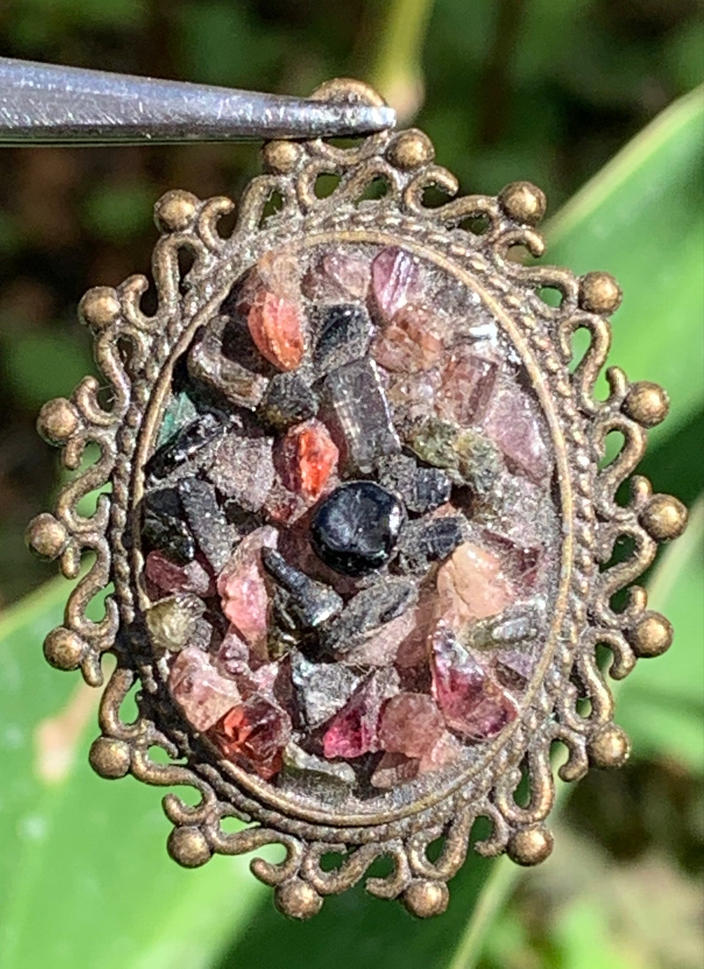 Médaillon couleur Bronze avec Tourmaline multicolore, de 36 mm de ht x30 x 8. Vendu avec un cordon noir réglable !