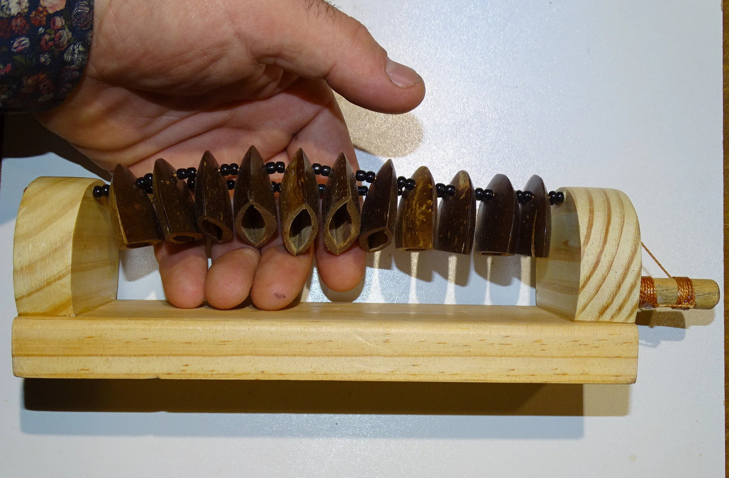 Shaker Guiro en graine sur base plate en bois. Peut également être utilisé comme shaker. Livré avec bâton ! 25 × 6,50 × 7 cm - 0,25 g !