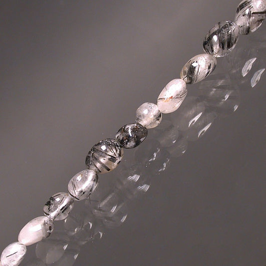 Cristal de roche (Quartz) avec Tourmaline noire, bracelet de 17 à 21cm, collier de 42cm et sautoir de 60cm. Perles de type 'Graine' de formes naturelles montées sur fil de haute résistance !