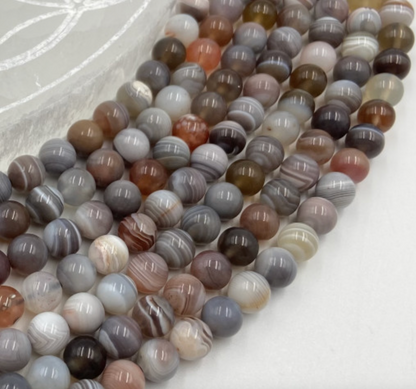 Agate Bostwana, perles rondes de 6 ou 8 mm, vendu en fil de perle ± 40 cm, en bracelet de 17 à 21cm, en collier de 45 ou sautoir de 60cm. Qualité AA à AAA !