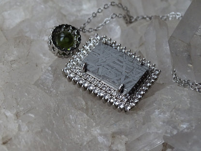 Pendentif 'Premium' style 'retro', en météorite 'Muonionalusta' de Suède et perle de Moldavite. Vendu avec chaînette de 45 cm en Argent. Poids 9,5 gr. Ø 38x22x0,9mm. Superbe pièce !