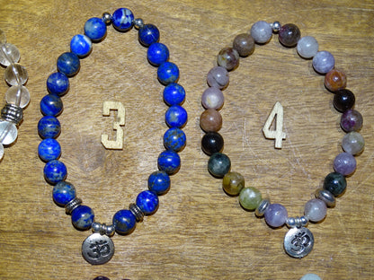 Collection de bracelets avec 3 charms au choix : Lotus Om ou Bouddha... En perle de 8mm + Médaille gravée de couleur argenté. Longueur au choix de 17 à 21 cm. Fait main par Zen Curiosity !