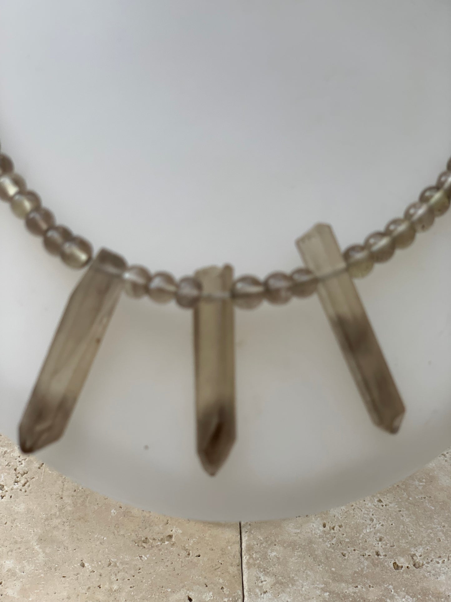 Cristal de roche/ Quartz fumé, en collier de 42 centimètres. Perle rondes de 4 à 7 millimètres avec 3 cristaux naturels en panoramique, fermoir de type 'crochet' !