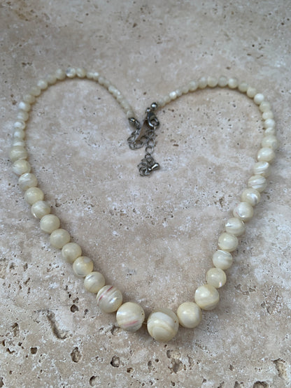 Perle de culture, 'collier/ chute de perle', de forme ronde de 4 à 10 millimètres de diamètre. 44 centimètres de longueur + 4 cm de rajout en chaînette. Fermoir de type 'mousqueton'. Très belle pièce !