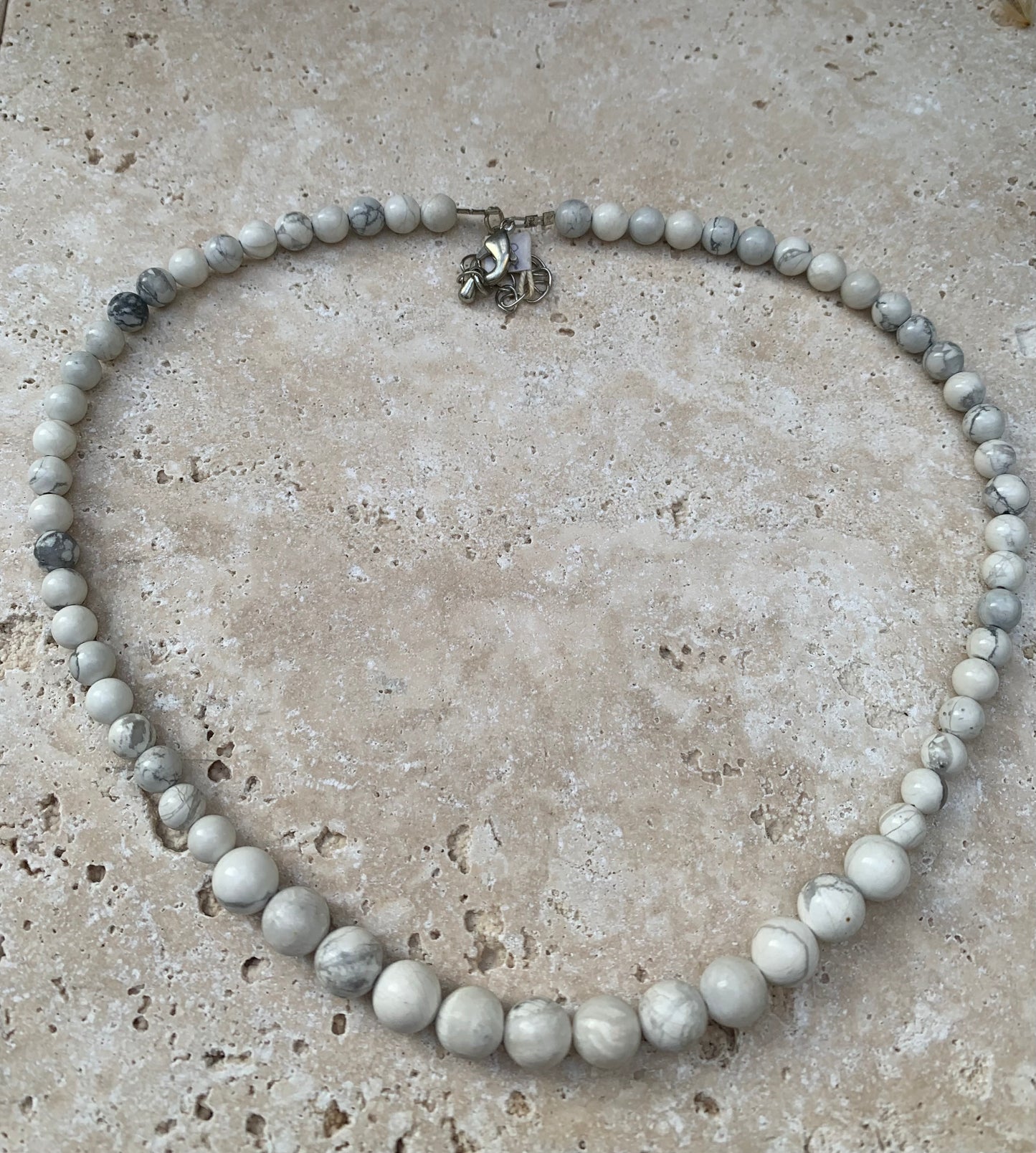 Howlite, 'collier/ chute de perle', de forme ronde de 4 à 10 mm - 44 cm + 4 cm de rajout en chaînette. Fermoir 'mousqueton'. Très belle pièce !