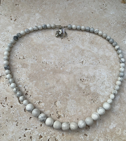 Howlite, 'collier/ chute de perle', de forme ronde de 4 à 10 mm - 44 cm + 4 cm de rajout en chaînette. Fermoir 'mousqueton'. Très belle pièce !